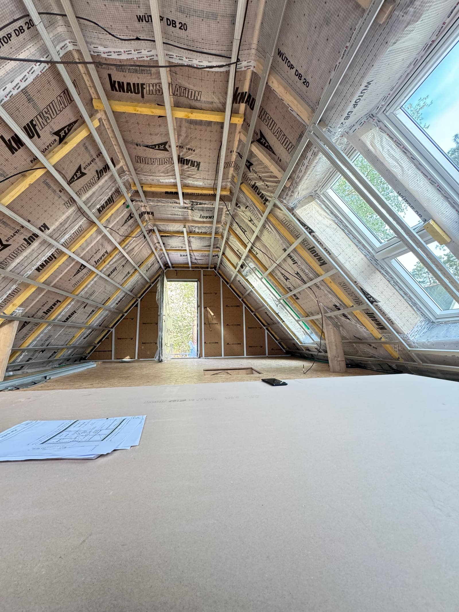 Combles en cours d'aménagement à Carnac : pare-vapeur et ossature posés sur pentes multiples, velux intégrés